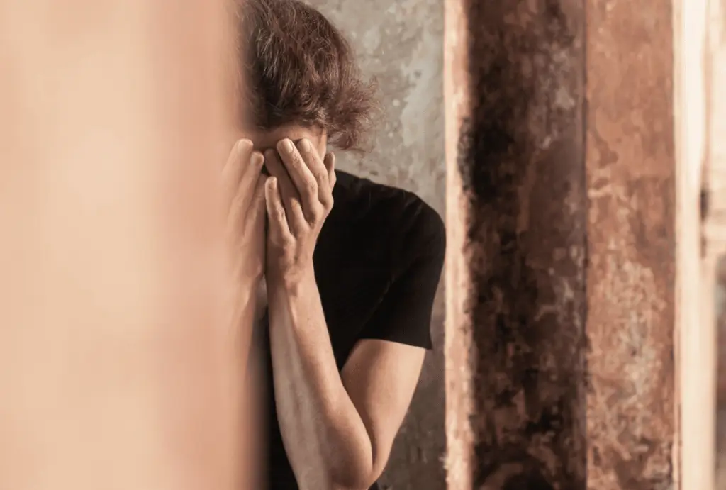 woman crying hands on face trauma and addiction Janina Fisher