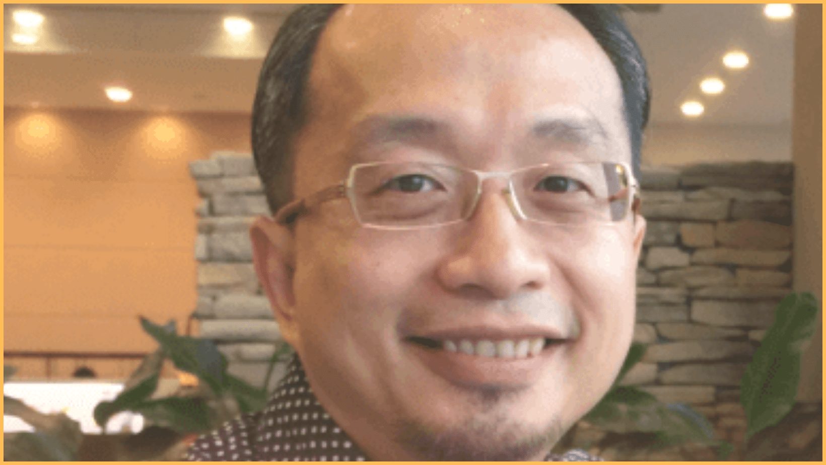 Smiling person with glasses indoors