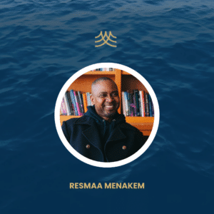 Person smiling in front of bookshelf, ocean background