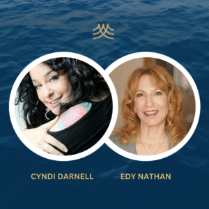 Two women smiling with ocean background.