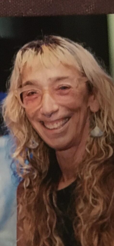 Smiling person with long curly hair