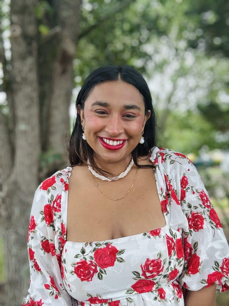 Smiling person wearing floral dress outdoors