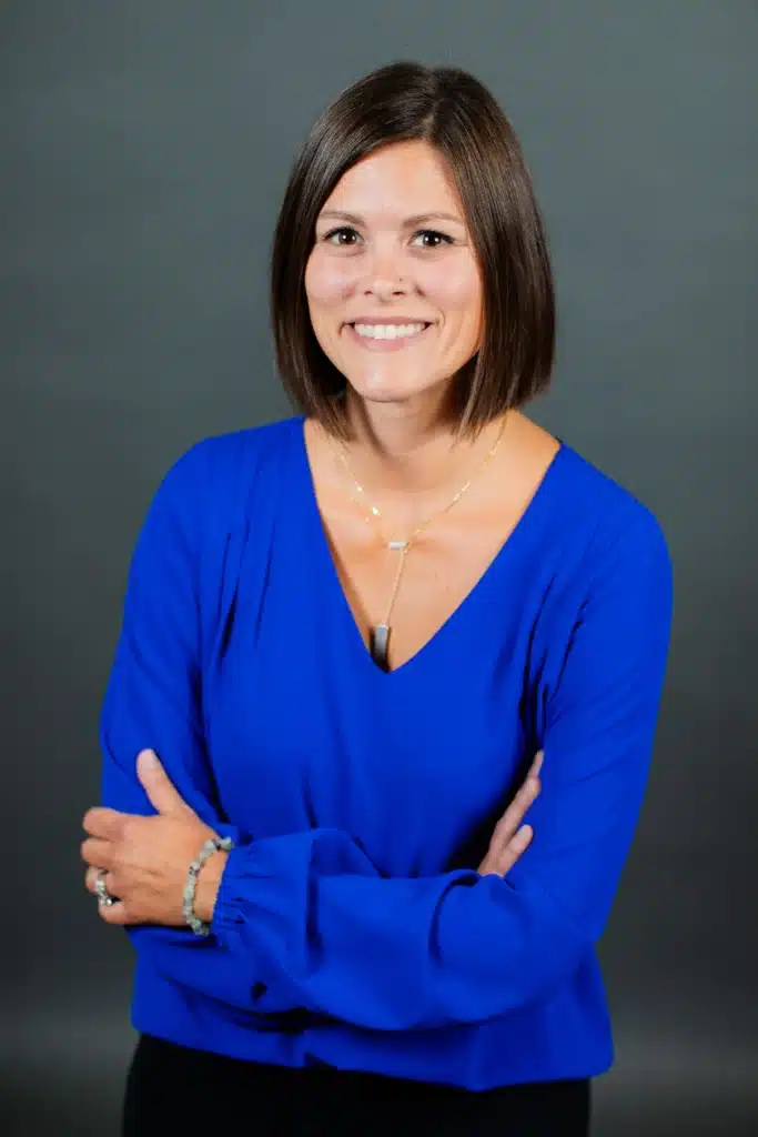 Smiling woman in blue blouse with crossed arms
