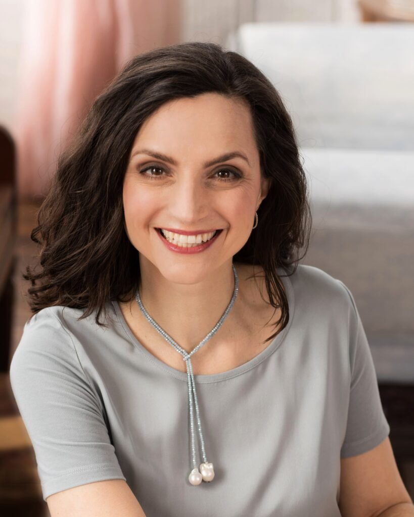 Smiling woman with brown hair wearing gray shirt
