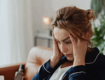 Woman stressed holding her head on couch
