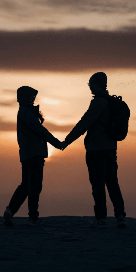 Couple holding hands at sunset